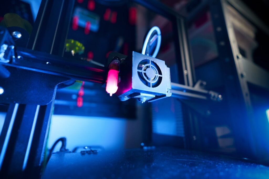 A close-up of an illuminated 3D printer in action, highlighting modern technology.